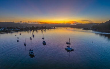 A fresh new day - sunrise waterscape with boats in the channel