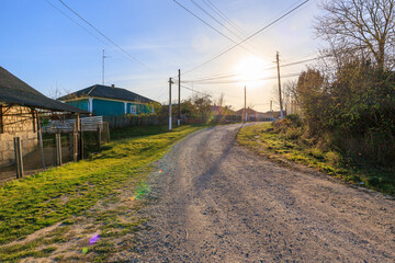 A rural road with a house in the background
