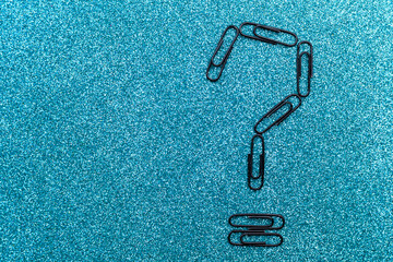 Question mark made from office paper clips. Background with selective focus and copy space