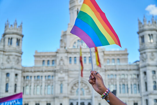 Hand waving rainbow flag at LGBTIQ pride event