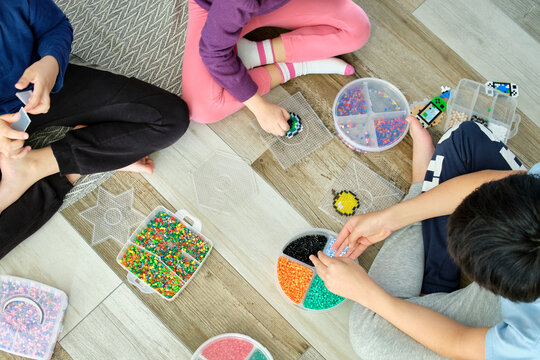 Anonymous children engaged in creative play with hama beads
