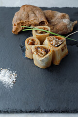 Grilled Bone Marrow with spoon decorated green onion With Rye Bread On Black Background. Vertical Orientation. View above. With Copy Space.