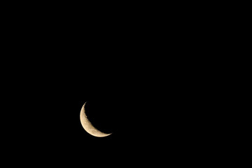 Obraz na płótnie Canvas Waning Crescent moon in dark black sky