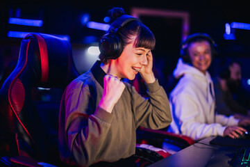 Pro eSports female gamer celebrating victory while playing online video game