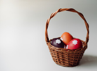 Cesta de Pascua con huevos sobre fondo blanco.