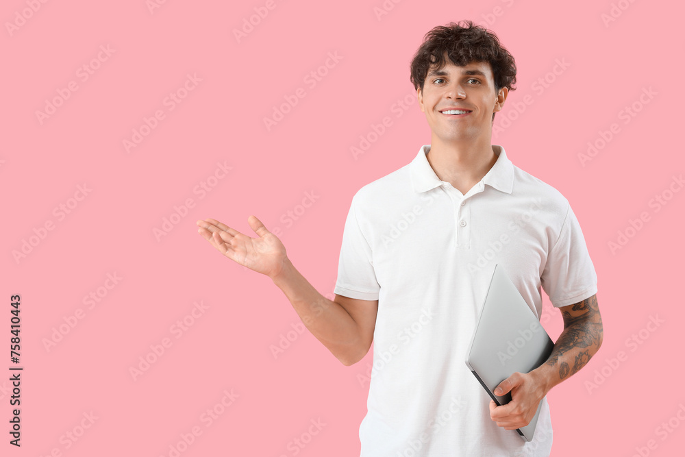 Poster male programmer with laptop showing something on pink background