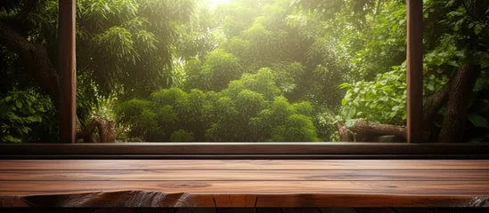 Poster A wooden table overlooking a natural landscape with trees and grass through an automotive window, creating a peaceful and serene environment © AkuAku