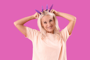 Mature woman with anal plugs on purple background