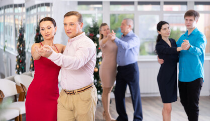 Elegant adult woman learning to dance Vienneze waltz with partner in dancing class. Active hobby concept..
