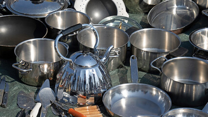 Silver pots and pans cookware sold on market outdoors