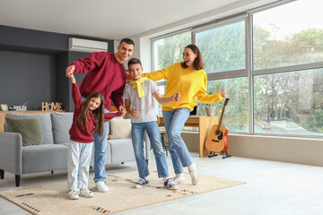 Little children with their parents dancing at home