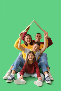 Fototapeta Little children with their parents and cardboard paper on green background