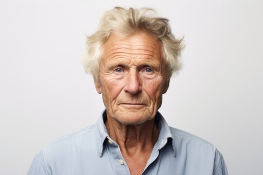 Portrait of a senior man looking at the camera over grey background