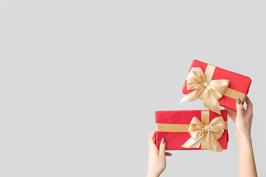 Female hands holding Christmas gift boxes on white background