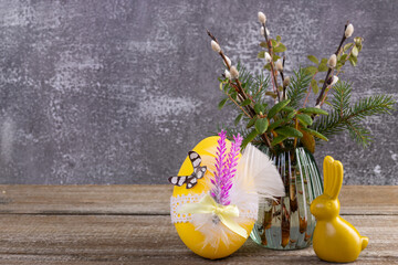 Wooden table with Easter bunny, egg and bunch of willow.