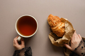 A cup of tea and a delicious croissant in your hands, good morning
