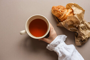A cup of tea and a delicious croissant in your hands, good morning