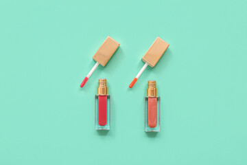Different lip glosses on turquoise background
