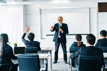 Senior leader speaker speaks to public people audience in training workshop or conference. Mature...