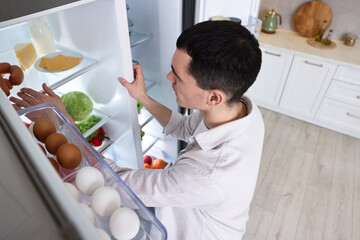 Man near refrigerator in kitchen at home, above view