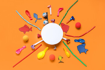 Blank card with paper fishes, funny glasses and party decor on orange background. April Fools Day...