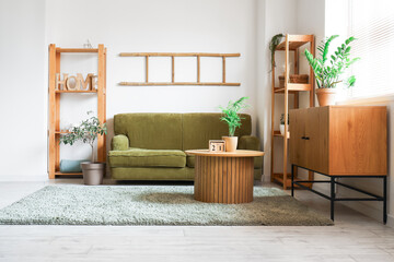 Sofa, wooden table and commode near white wall