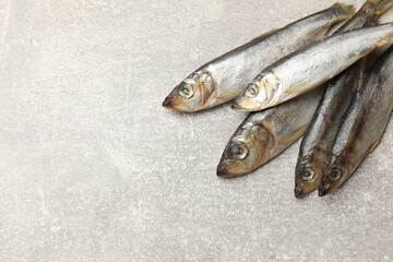 Fresh raw sprats on grey table, above view. Space for text