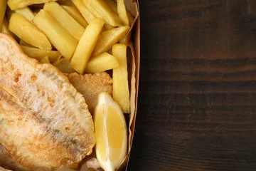 Fotobehang Delicious fish and chips in paper box on wooden table, top view. Space for text © New Africa