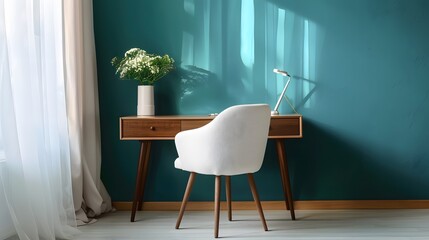 Home workplace with wooden drawer writing desk and white fabric chair near turquoise wall with copy space. Interior design of modern scandinavian home office. 
