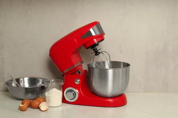 Fotobehang Modern red stand mixer, eggs, container with flour and bowl on white marble table. Space for text © New Africa