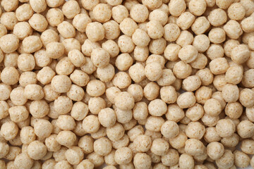 Tasty sweet cereal balls as background, top view