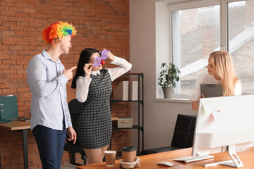 Business people with funny disguise in office. April Fools' Day celebration - obrazy, fototapety, plakaty