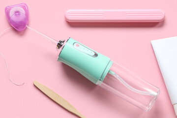 Set for dental hygiene with dental floss and oral irrigator on color background