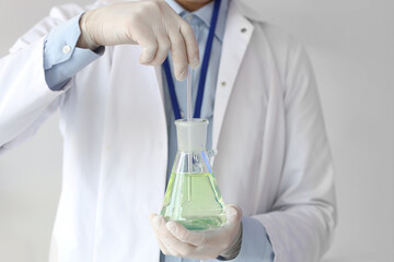 Male chemist with flask in laboratory, closeup