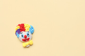 Clown figurine on beige background. April Fools Day celebration