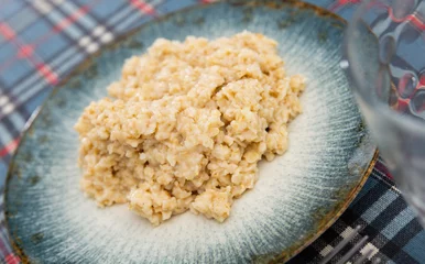 Foto op Plexiglas Appetizing milk oatmeal porridge served on plate for breakfast © JackF