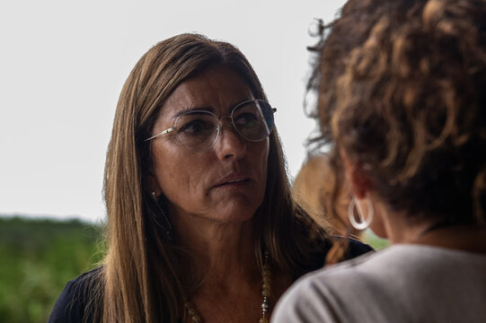 adult woman with glasses talking seriously to another