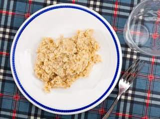Fotobehang Boiled oatmeal porridge served in white plate. Concept of diet food © JackF