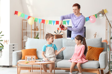 Father surprising his children with whoopee cushion at home. April Fool's Day prank