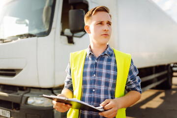 Truck driver occupation. Portrait of truck driver in casual clothes standing in front of truck...
