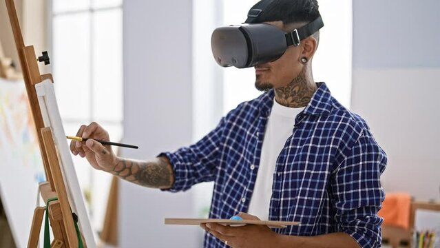 Spirited young latin man artist, draped in tattoos, draw-dazzling with virtual reality glasses in his vibrant art studio