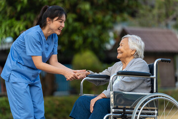 happy nurse take care and talking with senior woman patient in wheelchair at park, friendly caregiver