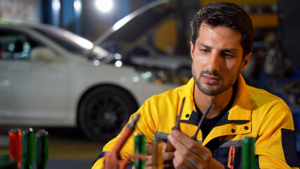 happy latin auto mechanic man checking and Store tools in garage cars service. hispanic technician...