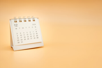 Simple desk calendar for December 2024 isolated on orange background. Calendar concept with copy space.