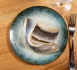 Fotobehang Sliced raw marinated fish herring served on platter © JackF