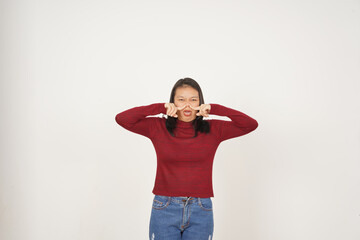 Young Asian woman in Red t-shirt Smelling something stinky and disgusting isolated on white...
