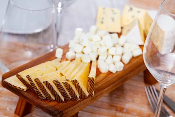 Fotobehang Different types of sliced cheeses served on board to table © JackF