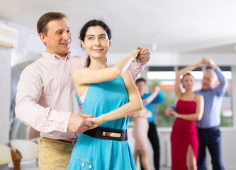 Adult man and young woman dancing in dance class