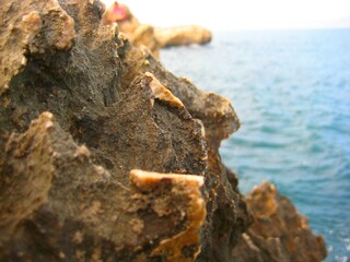 Close up of rocks with cliff, blurred image of outdoor nature landscape beach shore ocean coast line background space