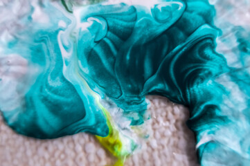 Close up of blue and white paint mixing in water, abstract background